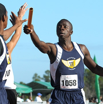 Disney High School Spring Training Event A long-distance relay runner hands a baton to his teammate