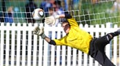 Disney Junior Showcase (Boys) A goal keeper goes vertical to stop a shot on goal during a soccer match