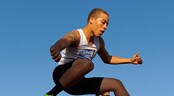 AAU Track and Field Club Championships A steeplechase runner jumps over a wooden barrier before his competitors