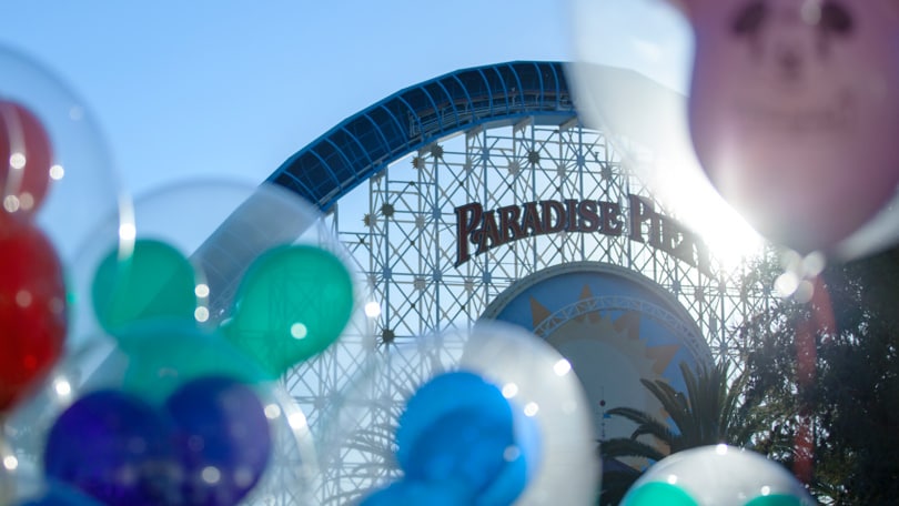 Mickey balloons in front of a roller coaster at Disney California Adventure Park