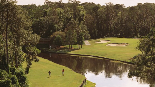 Two golfers near a lake on a golf course