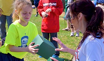 Pre-Order Food Delivery A woman delivers a box lunch to a girl on a sports field