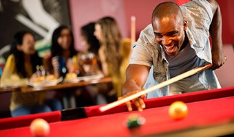 More Entertainment Options
A cheerful young man plays pool at Splitsville Luxury Lanes in Disney Springs
