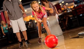 Splitsville Luxury Lanes
A smiling girl bowls at Splitsville Luxury Lanes while her dad watches in the background
