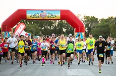 Runners cross the start line of Disney Cruise Line's Castaway Cay 5K for the Disney Castaway Cay Challenge.