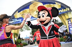 Runner high fives Minnie Mouse at the Walt Disney World Marathon finish line.