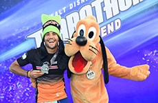 Runner celebrates with Pluto after the Walt Disney World 5K.
