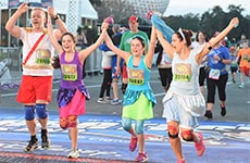 Family of runners crosses the finish line of the Walt Disney World 5K.