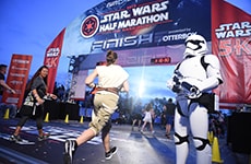 Runner races through the finish line during Star Wars Rival Run Weekend.