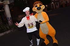 Runner dressed as Chef Louis with Timon during the Disney Wine & Dine Half Marathon