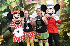 Runners celebrating with Mickey Mouse and Minnie Mouse after the Disney Wine & Dine Half Marathon