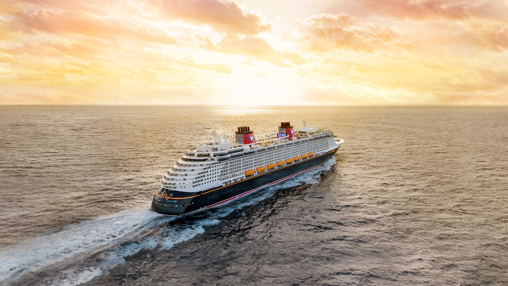 The Disney Dream crusie ship glides across the sea as the sun sets