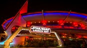 A large building with an arch and a sign that reads Star Wars Launch Bay