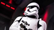 A Star Wars Stormtrooper searches a Star Destroyer with a pointed blaster rifle in hand