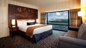 A king bed with a Sleeping Beauty Castle headboard across from a sofa and adjacent to a large window
