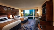 Two queen beds with magical headboards, a desk, TV-dresser, sofa and, beyond, a picture window