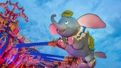 A Dumbo gondola flies high at Dumbo the Flying Elephant at Magic Kingdom park