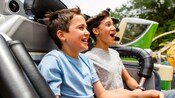 Two young brothers ride in a car on the Tomorrowland Speedway