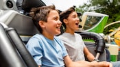 Two young brothers ride in a car on the Tomorrowland Speedway