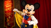 Master Magician Mickey grabs his cape while onstage at Town Square Theater in Magic Kingdom park