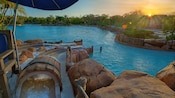 The sun peeks over trees, illuminating Bay Slides at Disney's Typhoon Lagoon water park