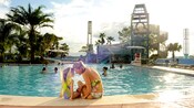 Madre e hija sentadas en la orilla de Bay Cove Pool en Bay Lake Tower en Disney's Contemporary Resort
