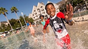 A smiling young boy enjoys pool time with his parents and sister at their Disney’s Yacht Club Resort A smiling young boy enjoys pool time with his parents and sister at their Disney’s Yacht Club Resort