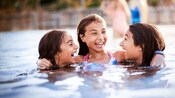 Tres chicas preadolescentes en una piscina del hotel de Walt Disney World Resort donde se hospedan Tres chicas preadolescentes en una piscina del hotel de Walt Disney World Resort donde se hospedan