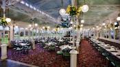 Main dining floor with round tables and banquette tables along the wall