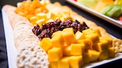 A platter with crackers, cheese and fruit