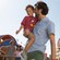 Pai leva seu filho pequeno pelo pátio do Disney’s All Star Sports Resort com a esposa e filha seguindo atrás