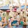 Tres niños disfrutan de kebabs y bebidas en una mesa al aire libre