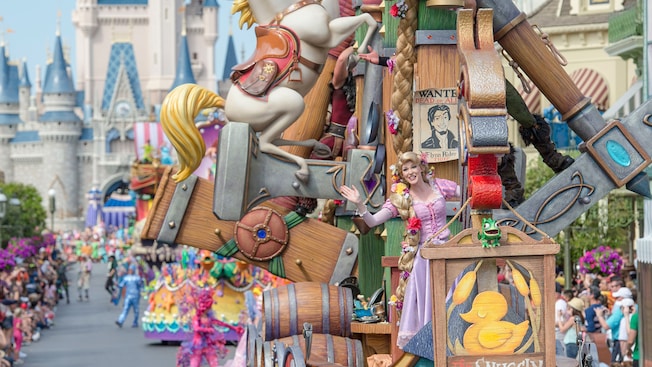 Top Five Shows at Disney World - A parade in front of Cinderella Castle featuring Rapunzel on a float shaped like a boat and more characters following behind her