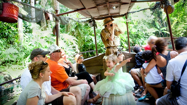 A young princess points to something exciting while the skipper shares stories with Guests aboard a Jungle Cruise boat.