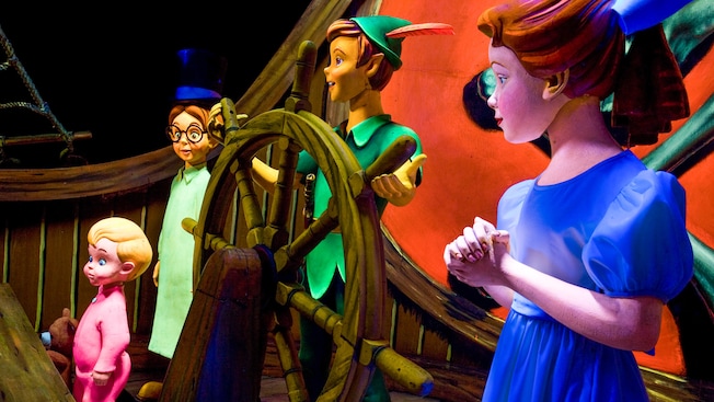 Wendy stands by Peter Pan's side as he steers a ship that takes the Darling children to Neverland