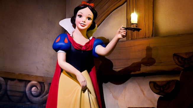 Snow White statue holds a candlestick at the start of Snow White's Scary Adventures