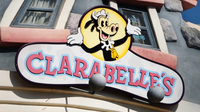 The sign for Clarabelle's snack stand at Disneyland Park features a smiling Clarabelle Cow