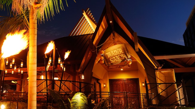Lit tiki torches at night along the path to Trader Sam's Enchanted Tiki Bar at Disneyland Hotel