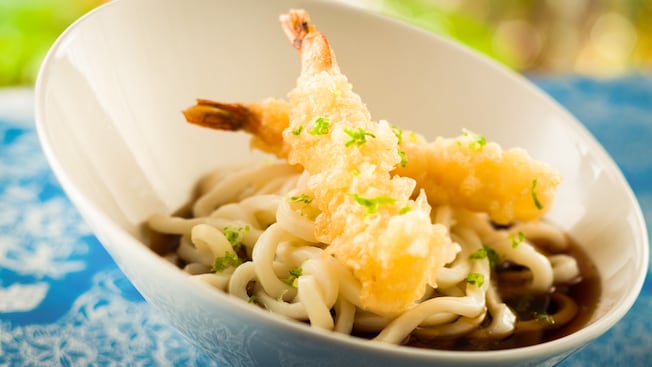 Bowl of udon noodles topped with 2 pieces of tempura shrimp