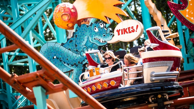 A mother and daughter spin while sliding on the tracks at the Primeval Whirl attraction