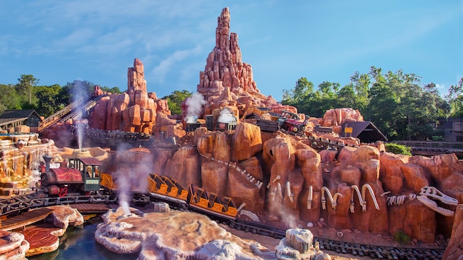 Mining trains zoom over rugged terrain on Big Thunder Mountain Railroad in Frontierland