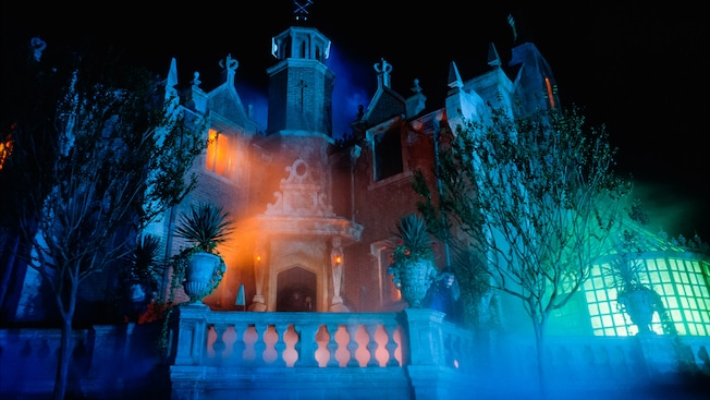 Spooky bluish glow of the exterior of the Haunted Mansion at night