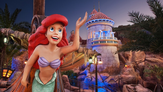 A figurehead of Ariel in front of Under the Sea ~ Journey of The Little Mermaid at night