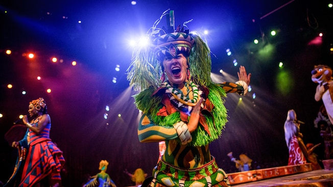 Costumed performers from Festival of the Lion King wave from the stage