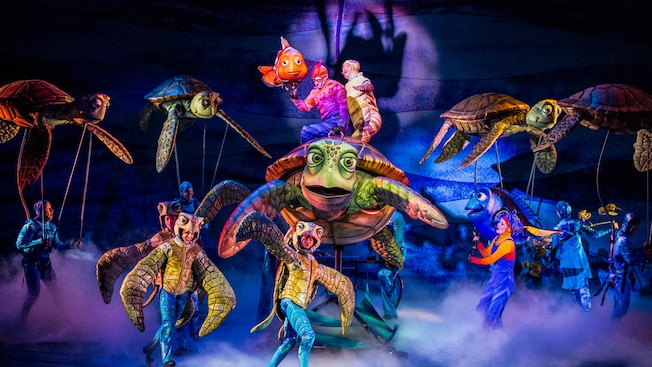 Marlin and sea turtles with their actor counterparts on stage at Finding Nemo - The Musical