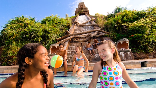 6 young teenagers enjoying The Lost City of Cibola Pool, an archeological-themed dig site with the pool slide