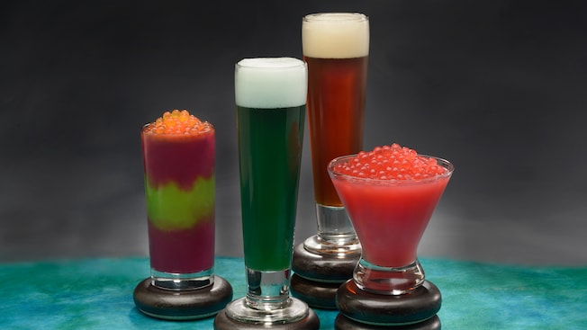 Two frozen beverages topped with boba balls, and two beers served in pilsner glasses