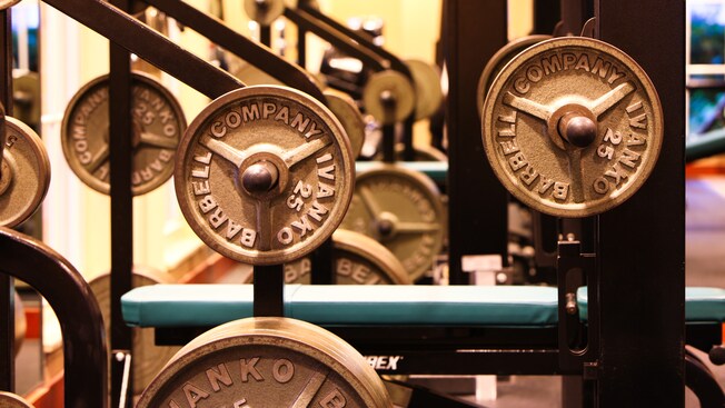 Woman working out with weights and man on a crosstrainer at the health club