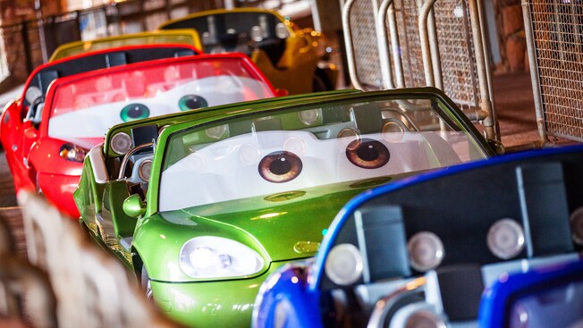 A lineup of cars waiting for drivers in the loading area at Radiator Springs Racers
