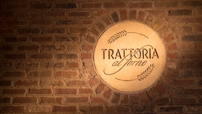 The Trattoria al Forno restaurant logo is embossed in a circle of stucco and framed by rustic brickwork.